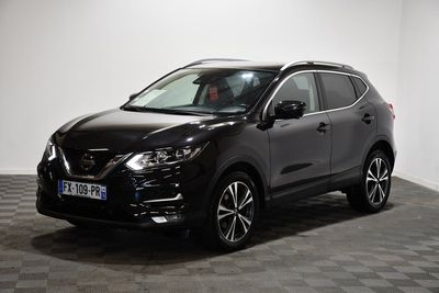 un SUV Nissan noir garé dans une pièce au sol carrelé