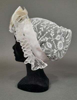 un gros plan d'un chapeau posé sur une tête de mannequin, elle-même posée sur une autre tête de mannequin