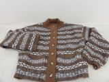 pull en maille marron et blanc posé sur un fond blanc