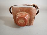 a small brown bag with a red stone on it