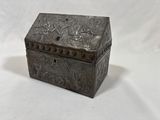 an old metal box with a lid that has a design on it