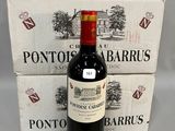 une bouteille de vin posée à côté de deux cartons de vin