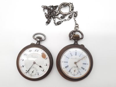 deux vieilles montres de poche posées l'une à côté de l'autre sur une surface blanche