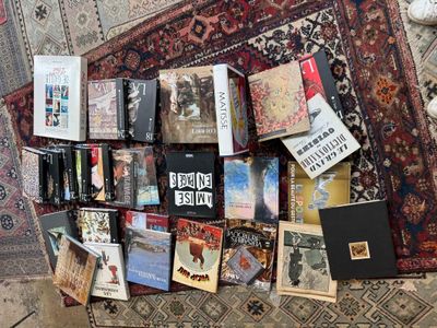 a lot of books on a rug on the floor
