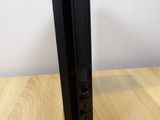 the back of a black video game console sitting on top of a wooden table