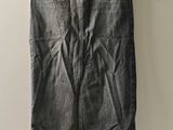 grey denim skirt hanging on a hanger against a white wall