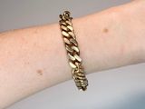 a gold bracelet on a woman ' s arm