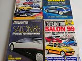 three magazines of different cars are sitting on a table