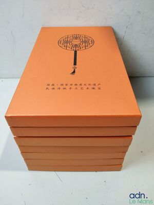 an orange box with a tree on it sitting on top of a table