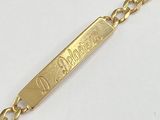 un gros plan d'un bracelet en or orné d'une plaque portant un nom