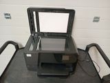 a printer that is sitting on the floor next to a chair