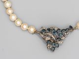 un gros plan sur un collier orné de perles et de pierres bleues