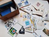 une boîte remplie de courrier posée sur une table, à côté d'une pile de cartes postales