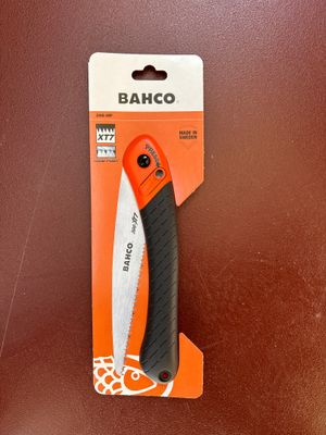 un couteau orange et noir posé sur une table marron