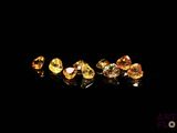 un gros plan sur un groupe de diamants jaunes posés sur une surface noire