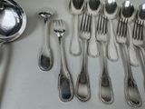 a lot of silver spoons and spoons on the table