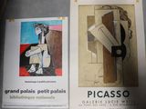two posters on the wall of a building with a clock