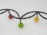 a metal sculpture of a branch with colorful balls