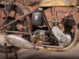 an old motorcycle parked in front of a brick wall