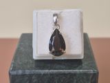 Pendentif en argent sterling et smokyite posé sur un bloc de marbre