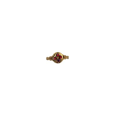 gros plan d'une bague en or avec une pierre rouge