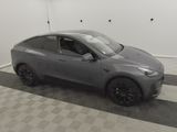 a gray tesla suv parked in a garage with a checkered floor