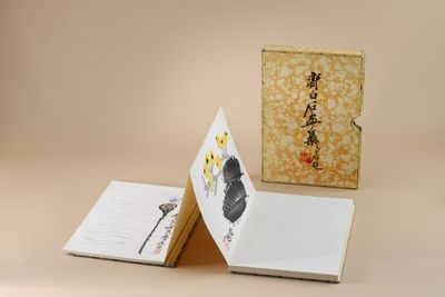 un livre ouvert posé sur une table, à côté d'un bloc-notes