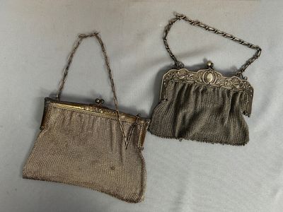 deux petits sacs à main munis de chaînes, suspendus sur une surface blanche