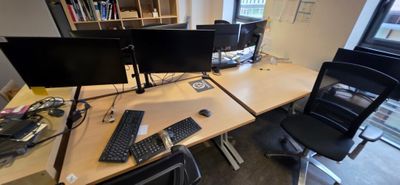 a desk with two computer monitors and a keyboard on it