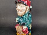 a figurine of a man sitting on a stool