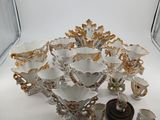 a white and gold bowl with a candle holder and other items