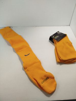 des chaussettes jaunes avec une étiquette noire, posées sur une surface blanche