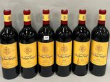 six bottles of red wine lined up in a row on a table
