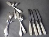 five forks and five knives on a table