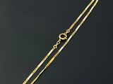 a close up of a gold chain on a black surface