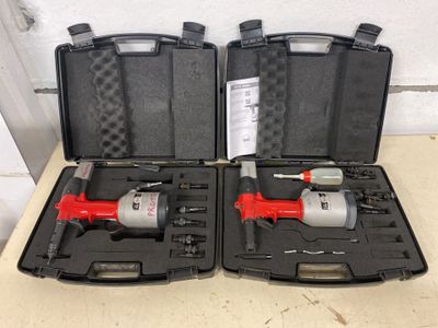 deux outils pneumatiques rangés dans un coffret, posés l'un à côté de l'autre sur une table