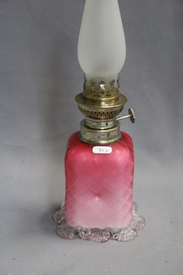 lampe à huile en verre rose surmontée d'un abat-jour en verre blanc