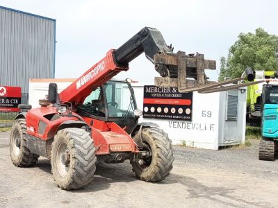 un tracteur rouge équipé d'une grue à l'arrière