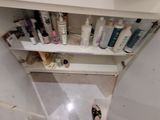 a small cabinet with a lot of hair products on it