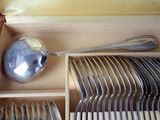 spoons, forks, and spoon rest in a wooden box on a table