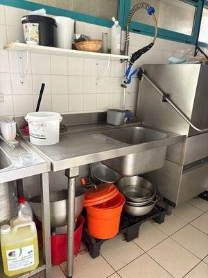 une grande cuisine en inox équipée d'un évier et d'une cuisinière