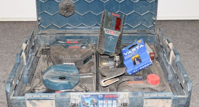 une boîte à outils bleue avec des outils sur le sol