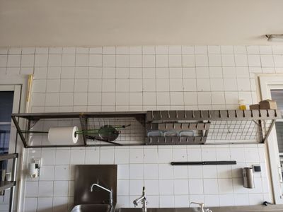 a kitchen with a sink and a shelf above the sink