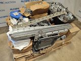 a pile of metal parts on a pallet in front of a wall