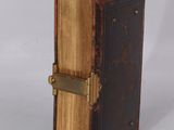 a small brown book with a metal clasp on it