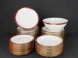 a set of six white and gold dinner plates with red rims