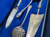 une mallette bleue contenant de l'argenterie, posée sur une table