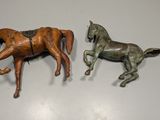 two figurines of horses that are on the wall