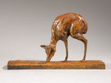 sculpture of a deer on a wooden base on a white background