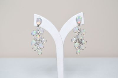 a close up of a pair of earrings on a white stand